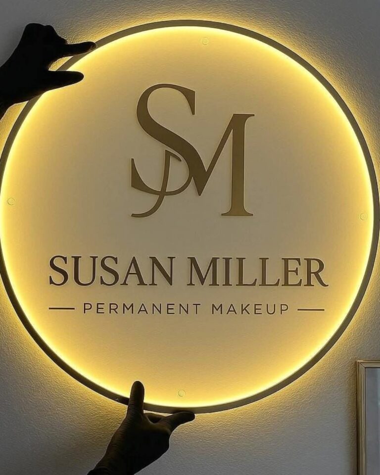 Round 2D logo board with warm LED back lighting and gold letters