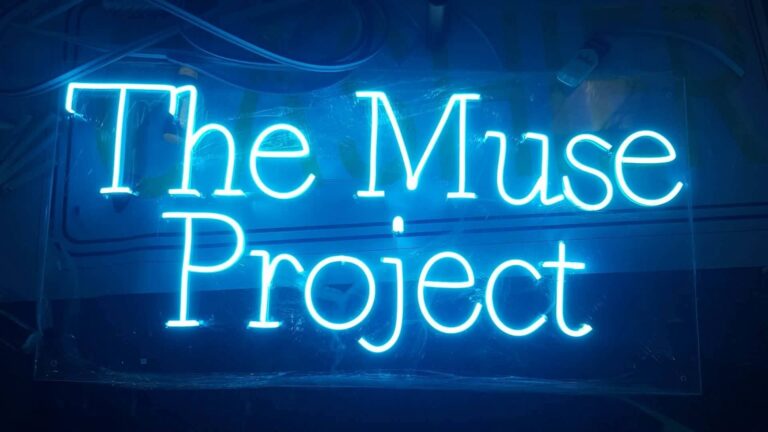 Blue custom name neon sign reading The Muse Project