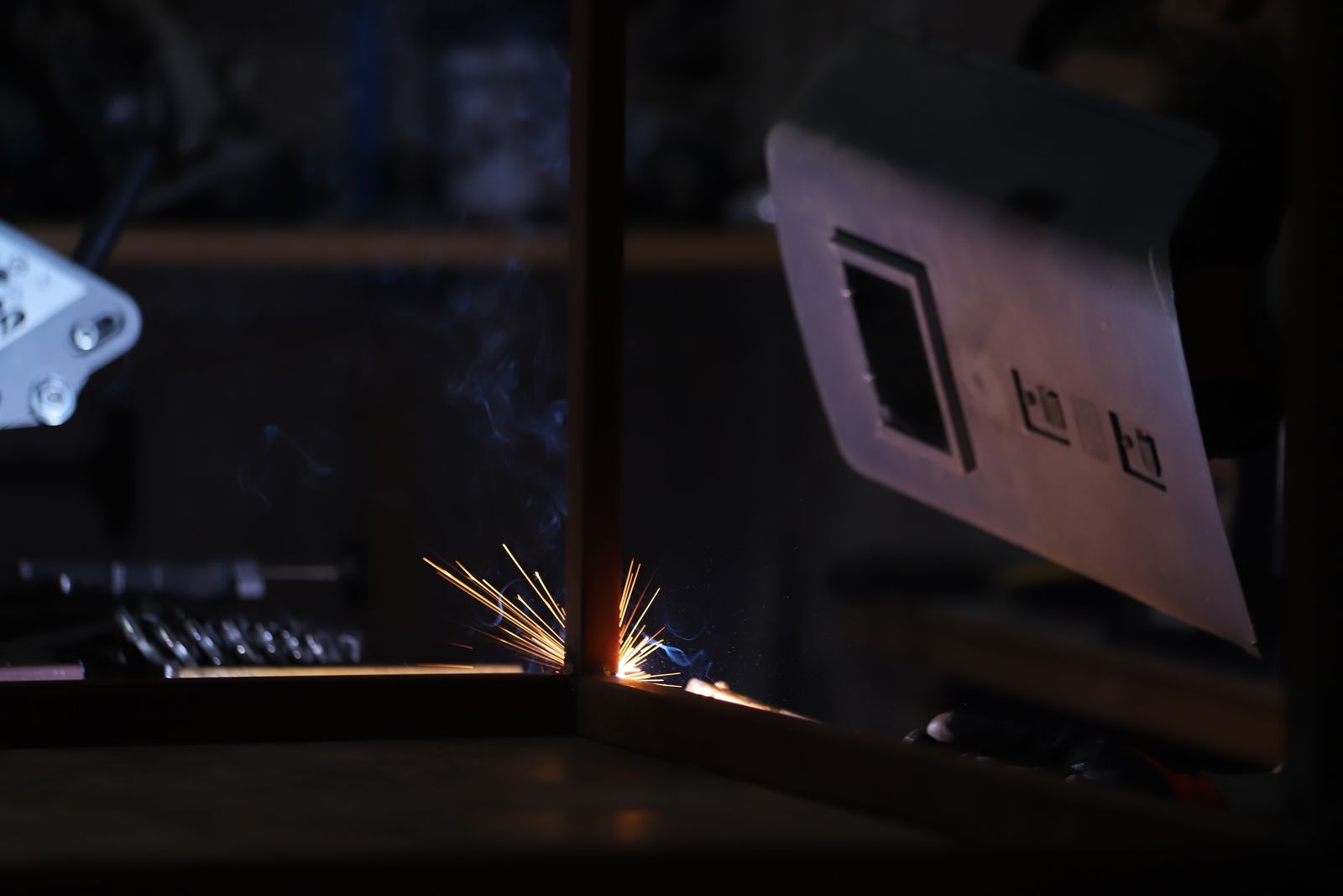 Sparks from metal fabrication in a dark workshop