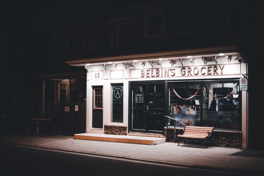 Shopfront with illuminated fascia signage at night